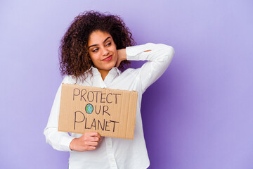 Young African American woman holding a girl power placard isolated on purple background touching back of head, thinking and making a choice.