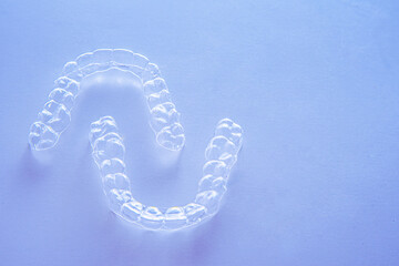 Invisible dental teeth brackets tooth aligners on blue background. Plastic braces dentistry...