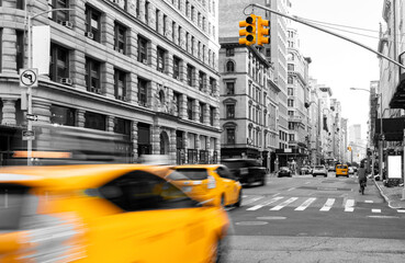 Yellow taxis driving in black and white street scene on Fifth Avenue in Manhattan New York City NYC