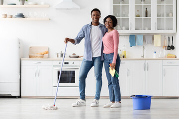 Beautiful african american couple cleaning kitchen together