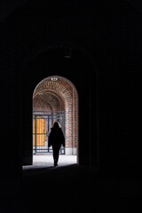 Fototapeta premium Stockholm, Sweden A woman walks under an archway in an outdoor corridor at the Stockholm Stadion Olympic stadium.