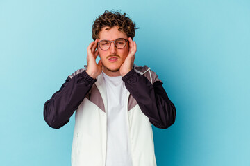 Young caucasian man wearing eyeglasses isolated on blue background touching temples and having headache.