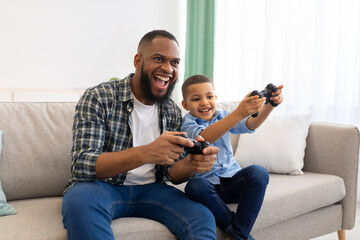 Joyful African Father And Kid Boy Playing Videogames At Home