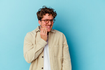 Young caucasian man wearing eyeglasses isolated on blue background having a strong teeth pain, molar ache.