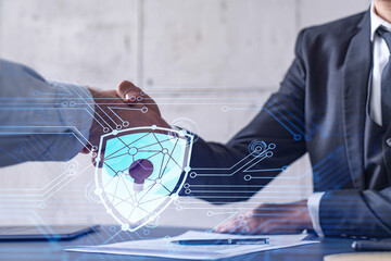 Handshake of two businessmen who enters into the contract to protect cyber security of...
