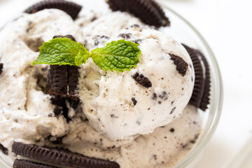Chocolate cookie and ice cream in a glass bowl with mint leaf on white wooden background, summer sweet and dessert