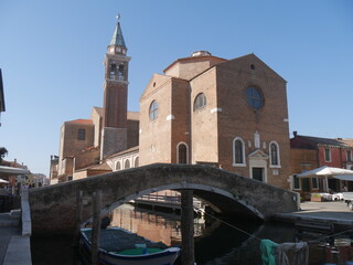 Fototapeta na wymiar Chioggia, San Giacomo Basilica along Canal Vena and its bridges