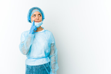 Young surgeon latin woman isolated on white background looking sideways with doubtful and skeptical expression.