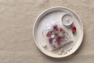 handmade bath salt with dried roses and herbs in mesh bag. Tube Tea. Diy aromatherapy products. linen cloth background