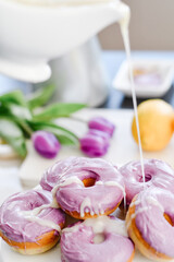 Homemade Purple donuts on dessert stand with Spring flowers