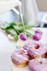 Homemade Purple donuts on dessert stand with Spring flowers