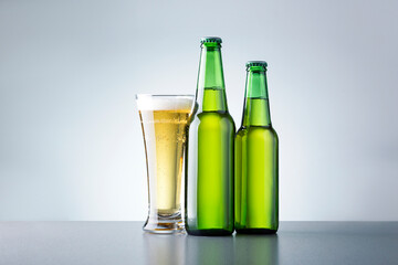 Glass Of Beer With Bottles On Grey Background. Non Alcoholic Beer.