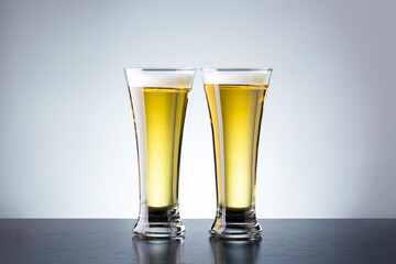 Two glass beer on dark counter against grey background with copy space.