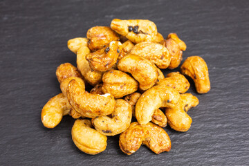 heap of roasted cashew nuts with black truffle - tuber aestivum