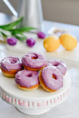 Homemade Purple donuts on dessert stand with Spring flowers