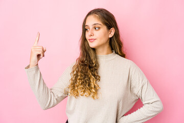 Young caucasian woman pointing with finger at you as if inviting come closer.