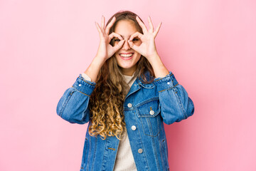 Young caucasian woman excited keeping ok gesture on eye.