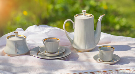 Coffee set on a white tablecloth on a sunny day.