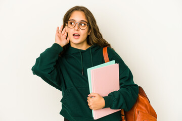 Fototapeta premium Young caucasian student woman isolated trying to listening a gossip.