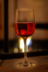 red wine in a glass in a glass cup against the background of a campfire and barbecue