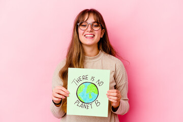 Young caucasian woman holding a There is not planet B isolated laughing and having fun.