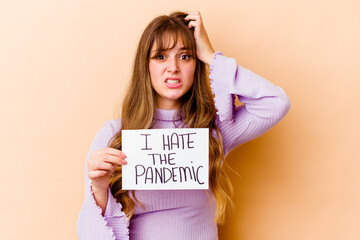Fototapeta na wymiar Young caucasian woman holding a I hate the pandemic placard isolated being shocked, she has remembered important meeting.
