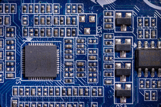 Close-up of microcircuits on blue motherboard in personal computer