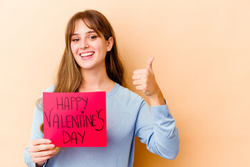 Fototapeta na wymiar Young caucasian woman holding a Happy Valentines day isolated smiling and raising thumb up