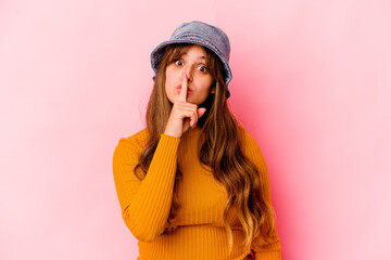 Young caucasian woman wearing fishermans hat isolated keeping a secret or asking for silence.