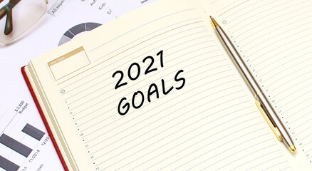 An open diary with text lies on an office desk with financial charts.