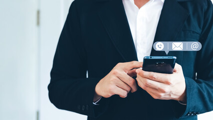 Hand of Businessman holding mobile smartphone. Contact Us, customer support concept. copy space.