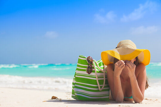 woman in bikini and with straw bag relaxingon tropical beach. Maldives