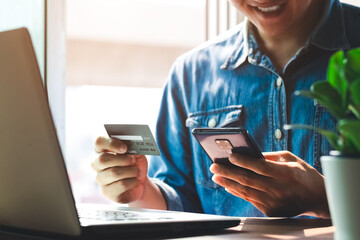 Men use credit cards to shop online and pay online or in digital banking on their smartphones at home.