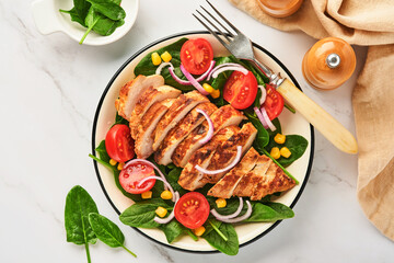 Chicken fillet with salad spinach, cherry tomatoes, cornflower and onion. Healthy food. Keto diet, diet lunch concept. Top view on white background.