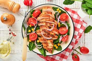Chicken fillet with salad spinach, cherry tomatoes, cornflower and onion. Healthy food. Keto diet, diet lunch concept. Top view on white background.
