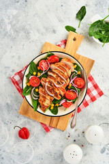 Chicken fillet with salad spinach, cherry tomatoes, cornflower and onion. Healthy food. Keto diet, diet lunch concept. Top view on white background.