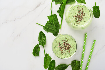Detox green smoothie with spinach, chia seeds and kiwi on a light gray slate, stone or concrete background. Top view with copy space.