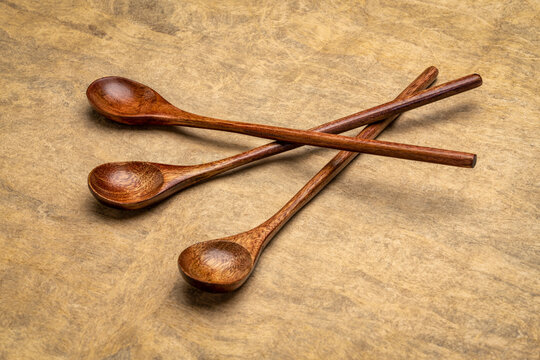 three wooden teaspoons over handmade bark paper, cooking utensils still life