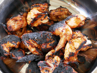 Pieces of chicken that have been grilled and ready to serve. Has been seasoned with special spices before being grilled.