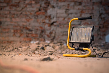 Spotlight close up on the dirty floor of construction site on the old brick wall background.