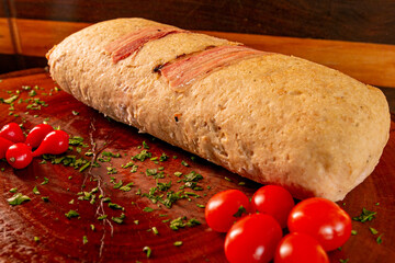 roulade stuffed with ham and bacon cheese on top of wooden board