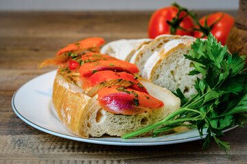 Red fish cut into pieces on a large piece of bread on a plate with parsley
