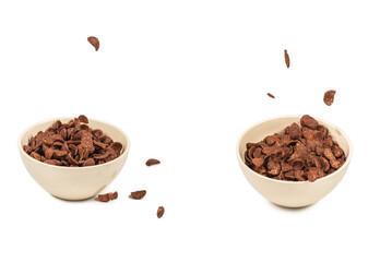 Chocolate corn flakes falling to the white bowl isolated on white. Motion.
