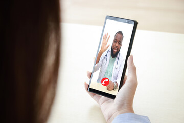 Female patient holds a black smartphone chatting online with an African American male doctor. Concept of online communication technology. Doctors can examine patients through video calls. Clipping Pat