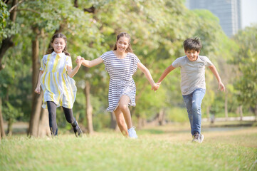 Naklejka na ściany i meble A half-Thai-Indian boy and a half-Thai-European girl friend races in a park while learning outside of school