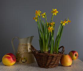 Floral arrangement in a wicker basket and ripe apples. Vintage.