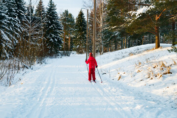 Small child in the ski track at winter forest in Finland.