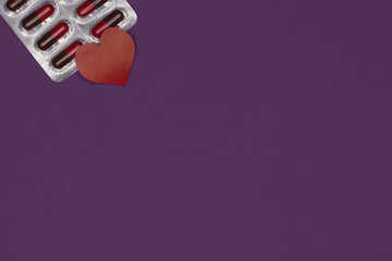 A package of pills with a heart on a purple background, a place under the text. Epilepsy Day....