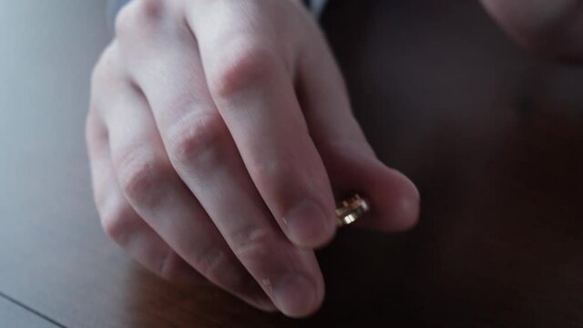 Fading feeling of love. Man takes off his wedding ring from his finger
