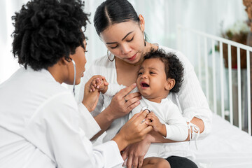 African female pediatrician hold stethoscope exam child boy patient visit doctor with mother